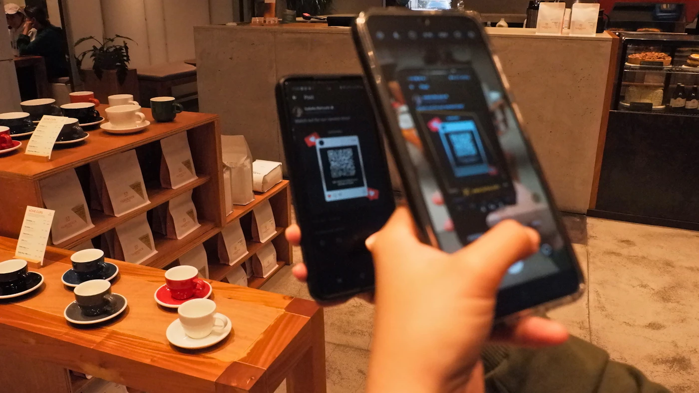Ponsel digunakan untuk memindai kode QR di sebuah counter